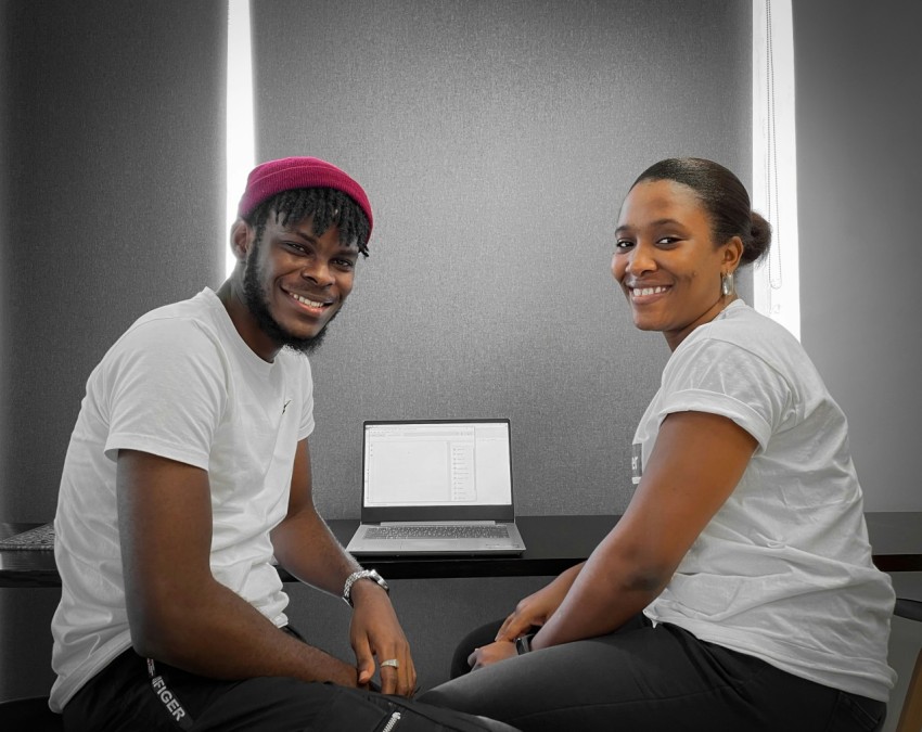 a man and a woman sitting next to each other in front of a laptop E2vYTaz