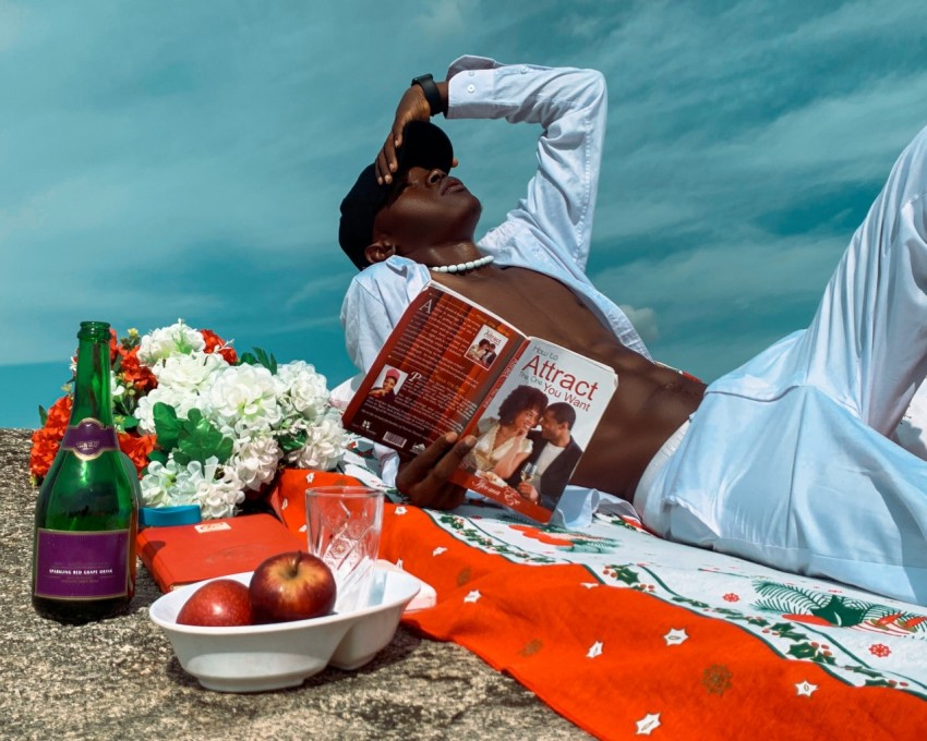 a woman laying on a beach next to a bottle of wine