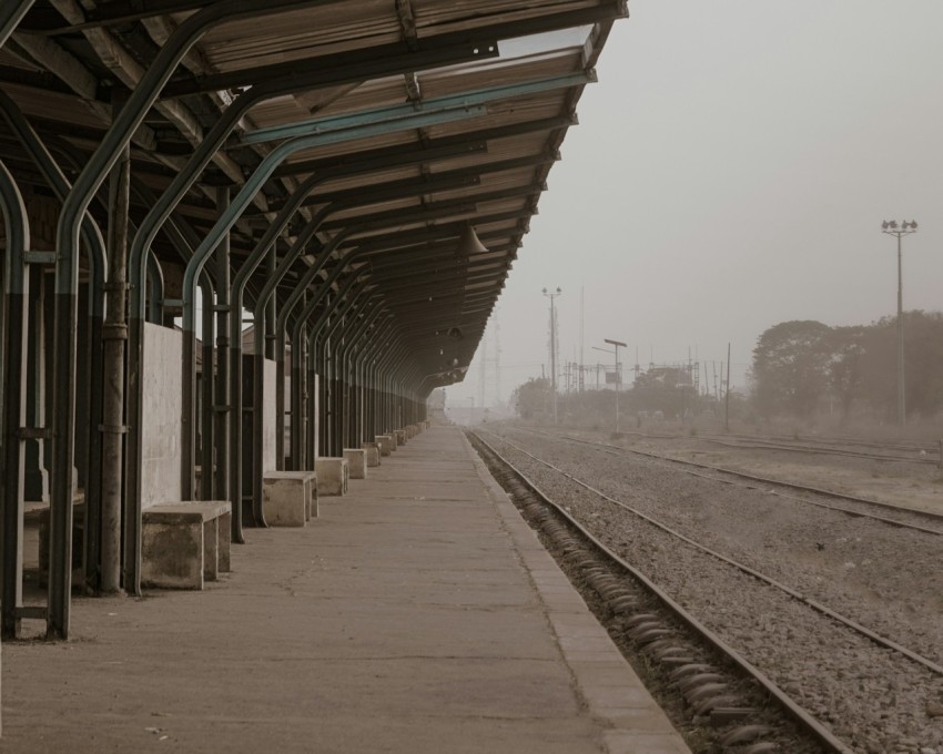 a train station with a train on a foggy day