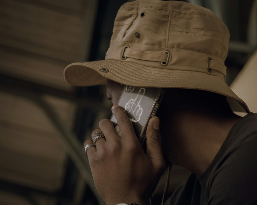 a woman wearing a hat talking on a cell phone RKKR3oQE