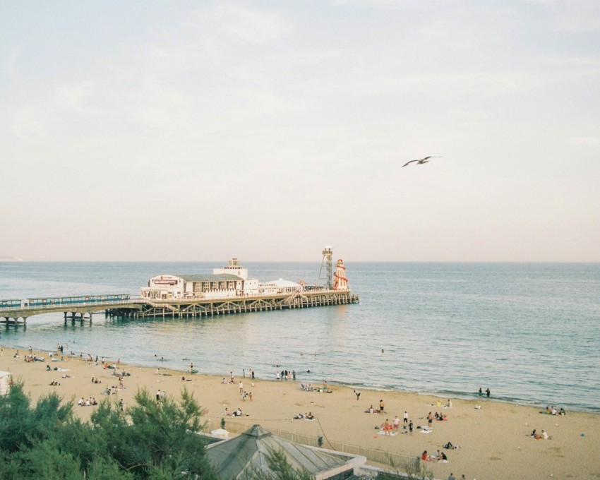 a pier with people on it and a large body of water in the background