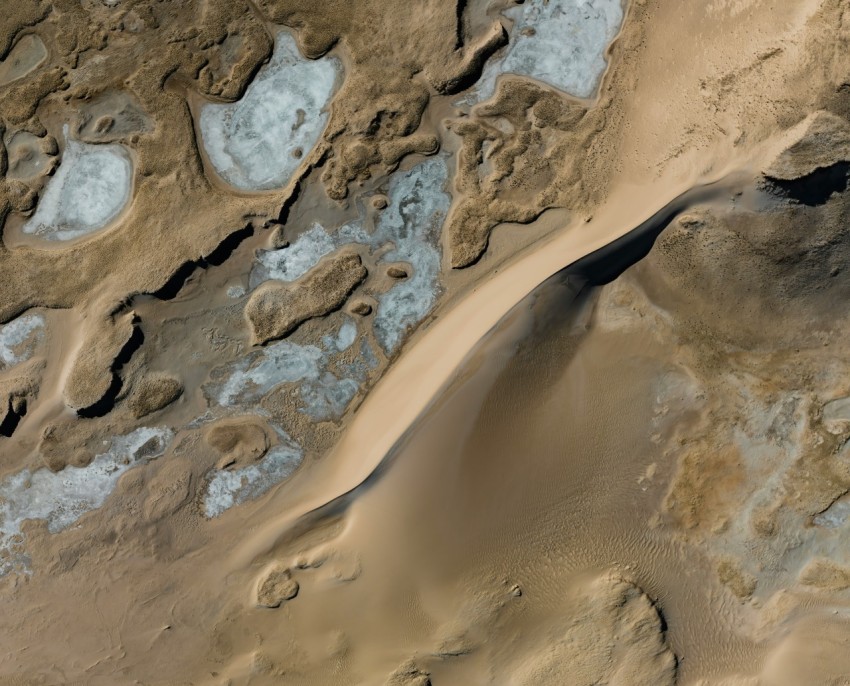 an aerial view of sand dunes and water