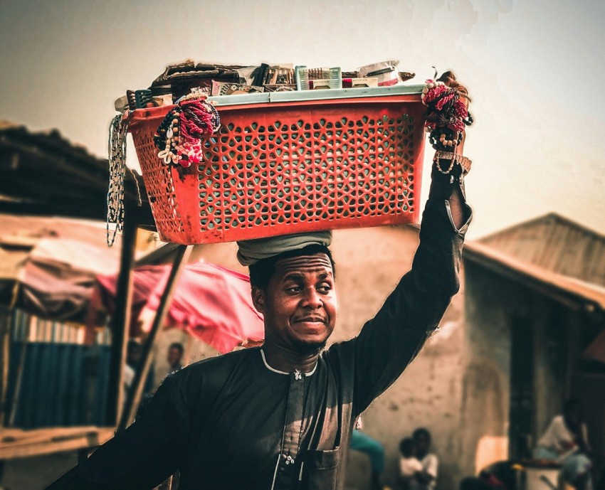 a man carrying a large red box on his head