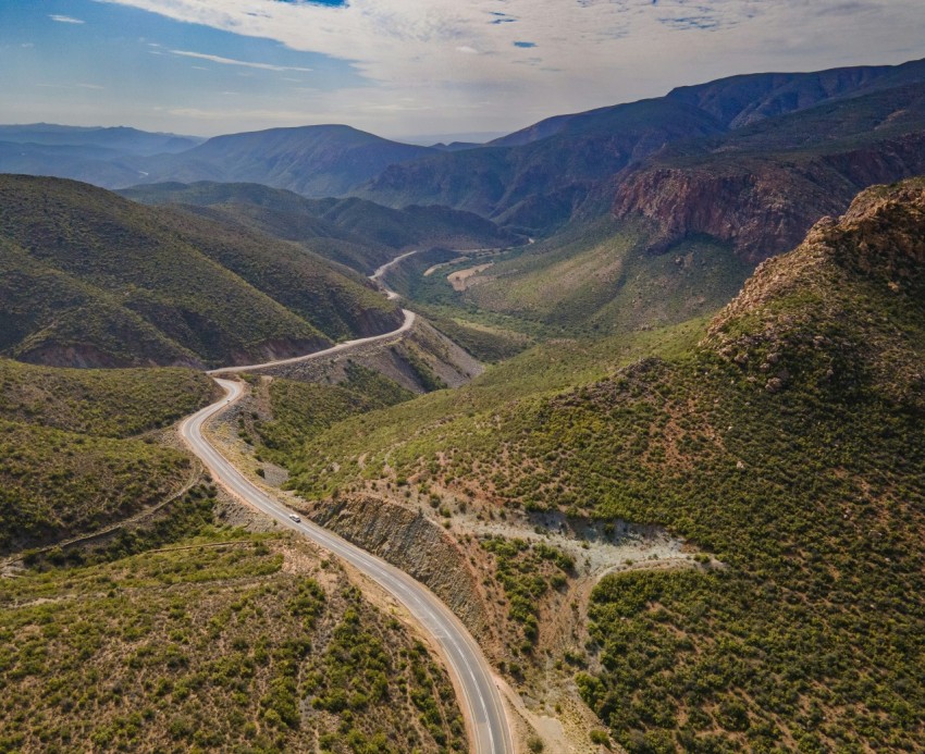 an aerial view of a winding road in the mountains