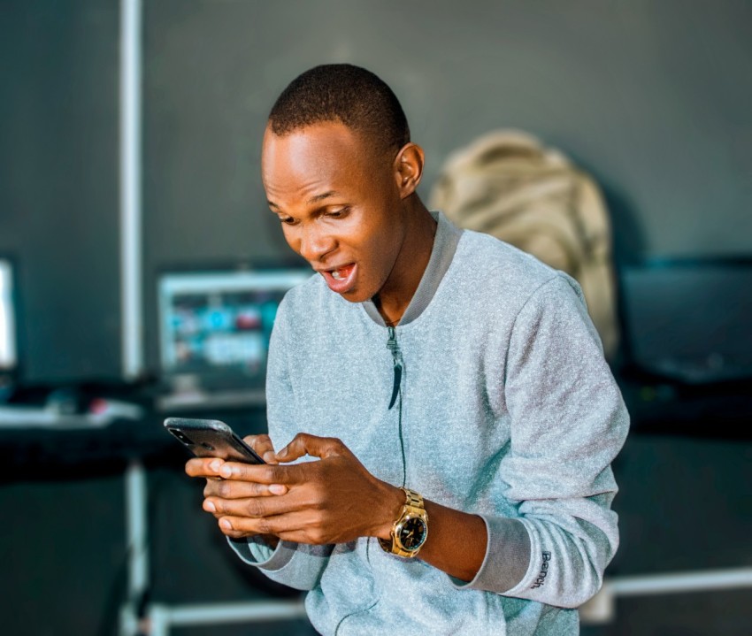 a man looking at his cell phone and laughing