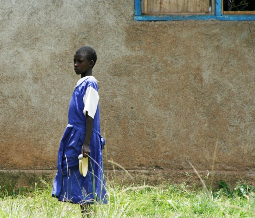 boy in blue and white school uniform standing on green grass during daytime