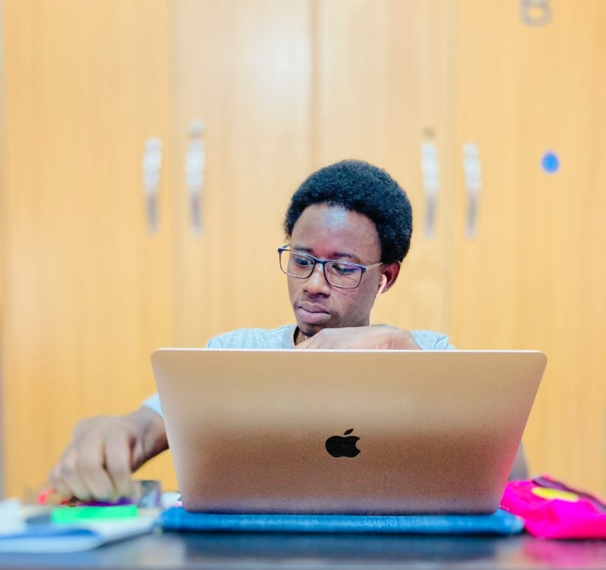 a man sitting at a table using a laptop computer