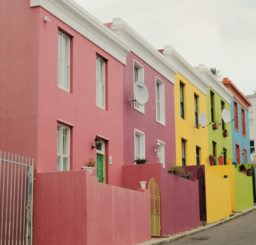 a row of multi colored houses on a street