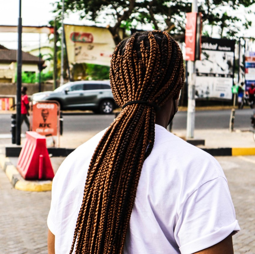 a person with a long braid standing on a street