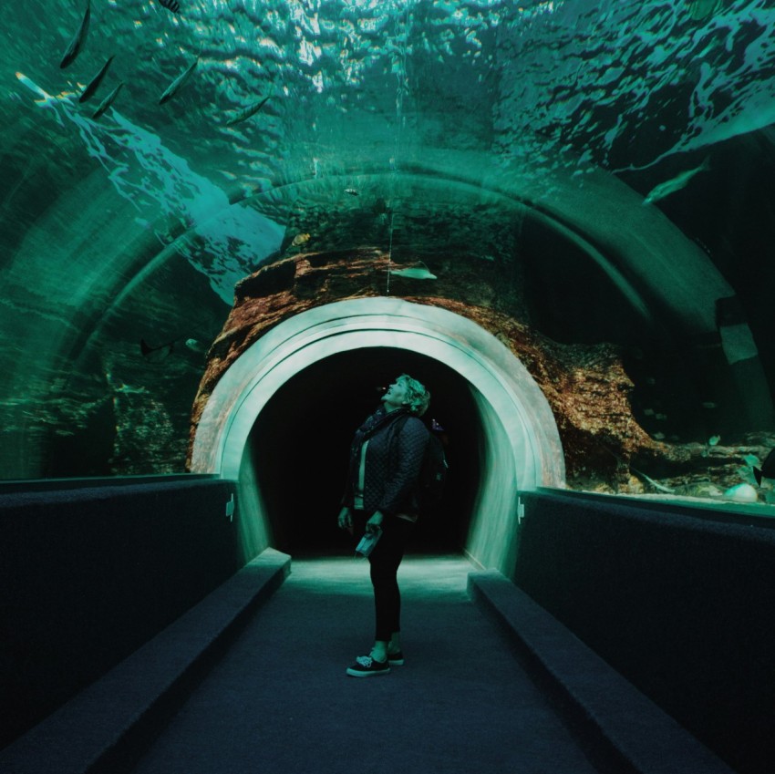 woman in black jacket and black pants standing on tunnel