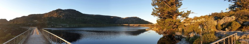 a bridge over a lake with mountains in the background