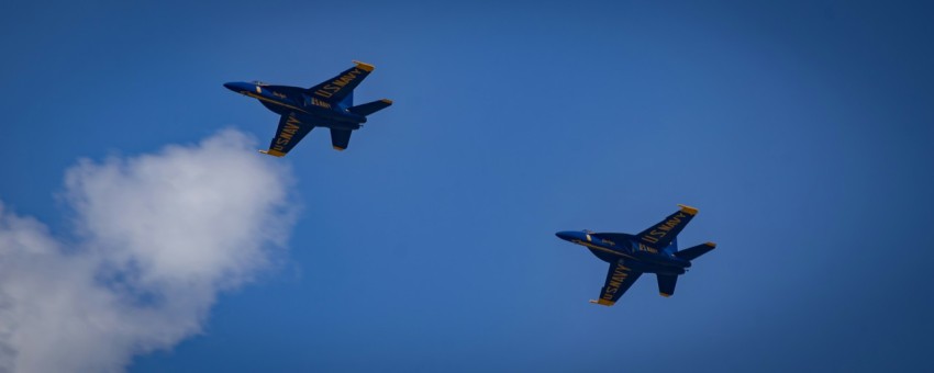 two planes flying in the sky with a cloud in the foreground