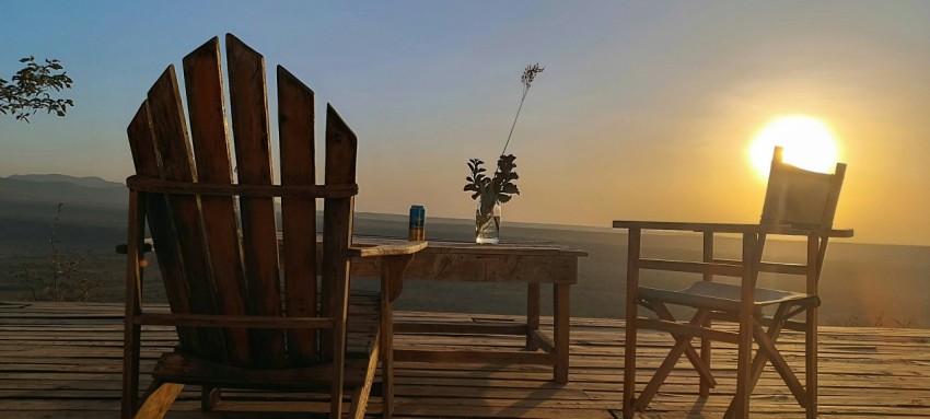 a couple of chairs sitting on top of a wooden deck