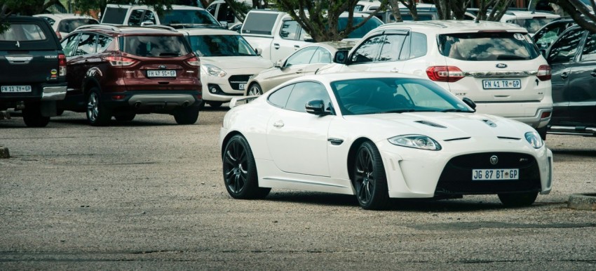 a white sports car parked in a parking lot