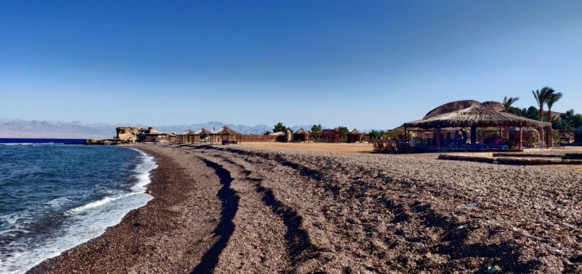 a sandy beach with huts 1y3zH3C