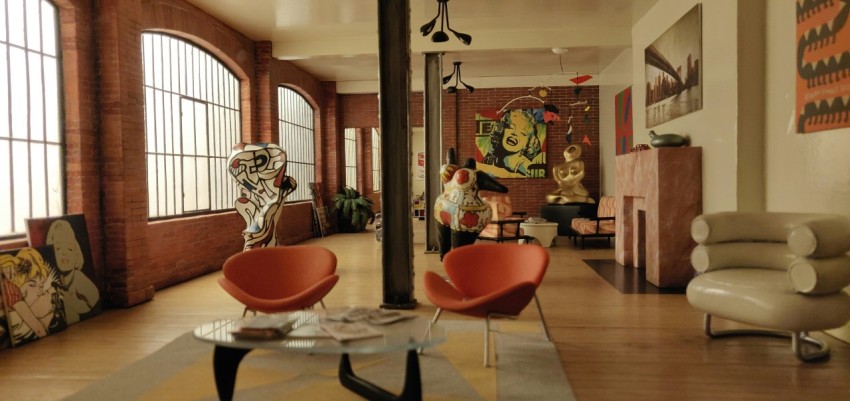 a living room filled with furniture and large windows