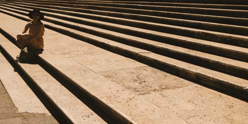 a person sitting on the steps of a building U74VDmP