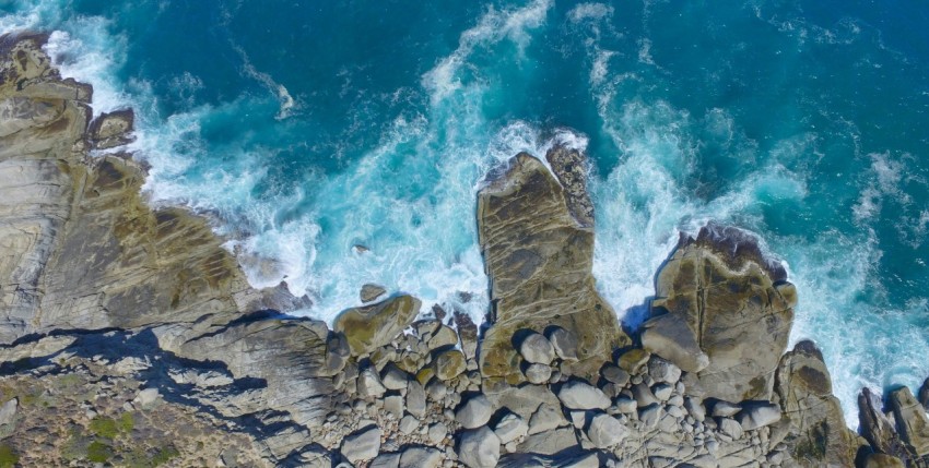 aerial photo of body of water near rock formation