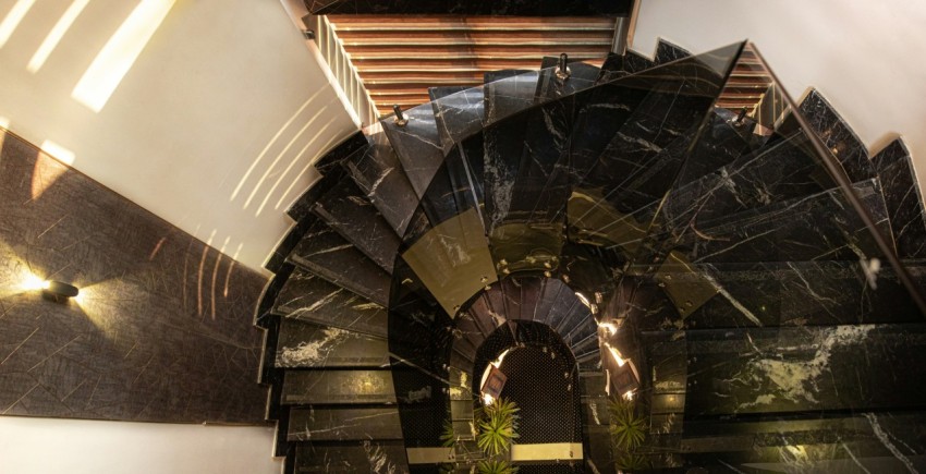 a spiral staircase in a building with a mirror on the wall