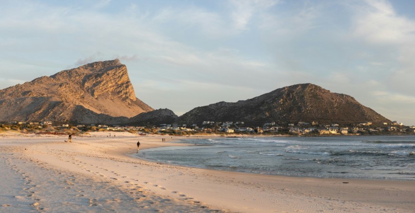 a sandy beach with a mountain in the background