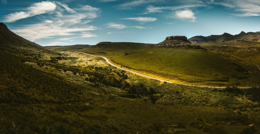 a winding road in the middle of a lush green valley O04PGFOkg