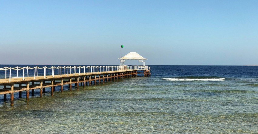 a long pier stretches out into the ocean