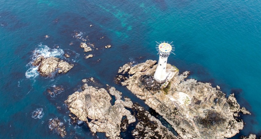 aerial photography of lighthouse near body of water lZa5b4