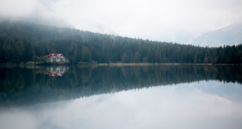 house beside body of water and surrounded of green trees LFRUBa