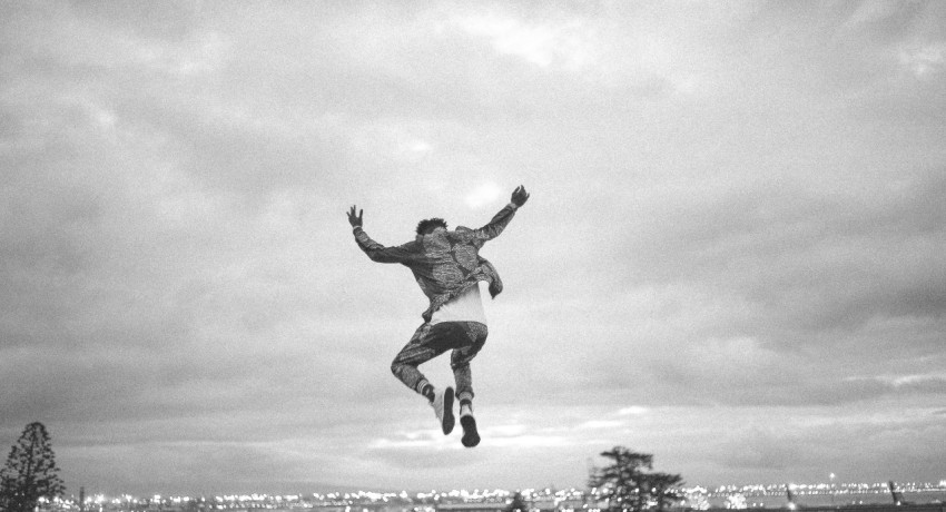 greyscale photo of person jumping