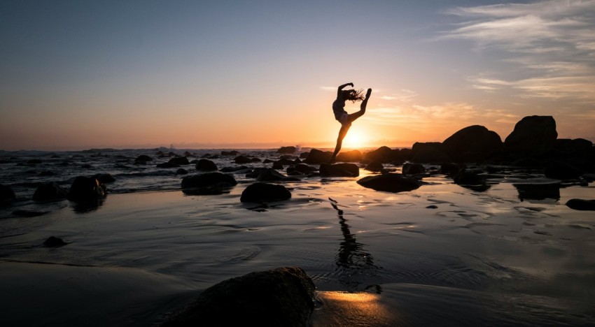 silhouette photography of woman standing on rock 8