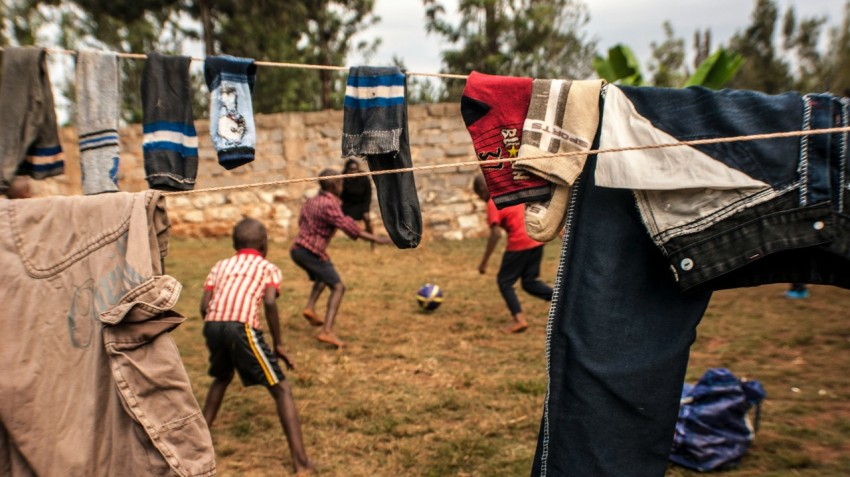 two boys playing under clothesline