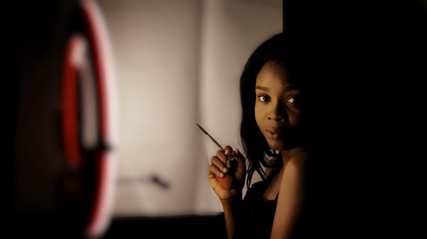 woman holding black pen in front of white wall