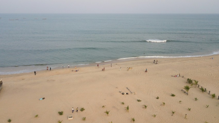 a group of people standing on top of a sandy beach