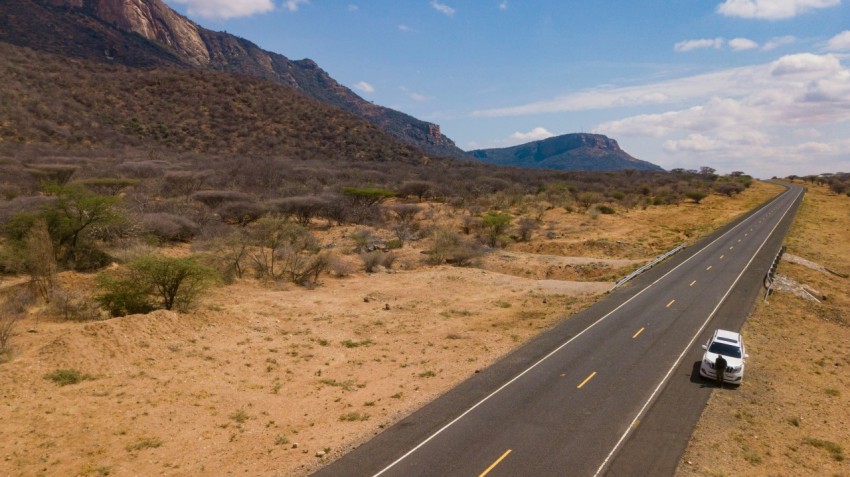 a car driving down a road in the middle of the desert