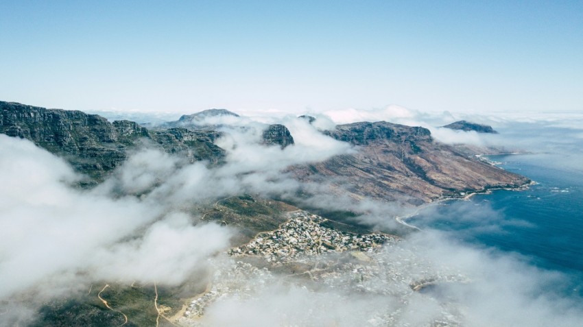 photo of mountains beside body of water filled with fogs 7