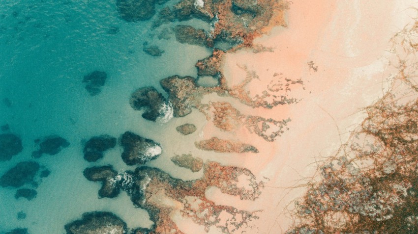 an aerial view of a beach with rocks and water K91P Xge2