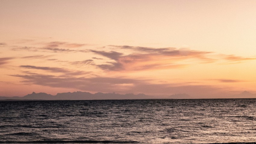 body of water under cloudy sky during sunset