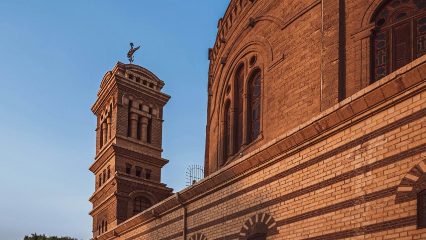 a tall brick building with a clock tower jnaJHHt