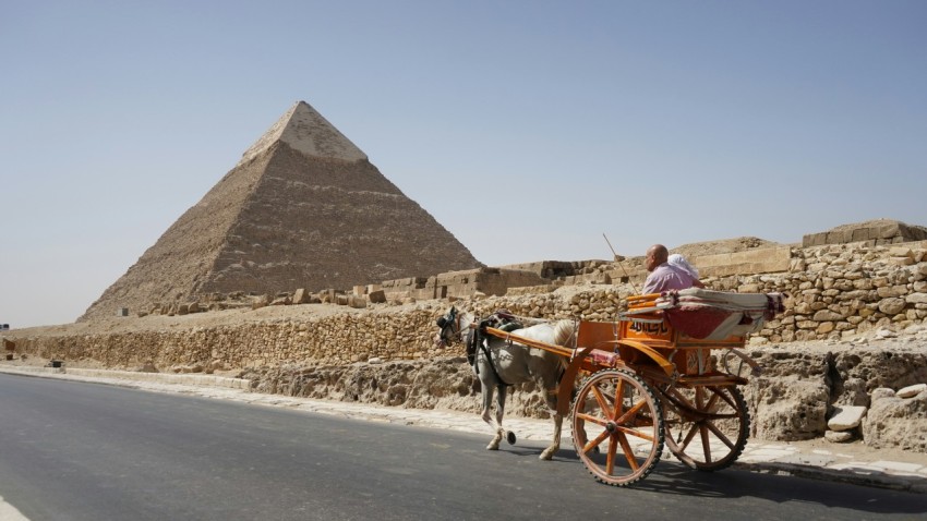 a horse drawn carriage in front of a pyramid 6c