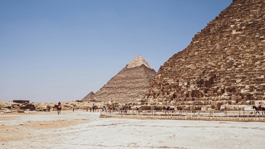 a group of people walking around a pyramid