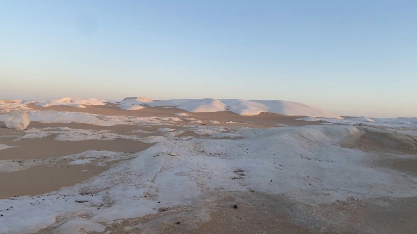 a snowy landscape with mountains in the distance