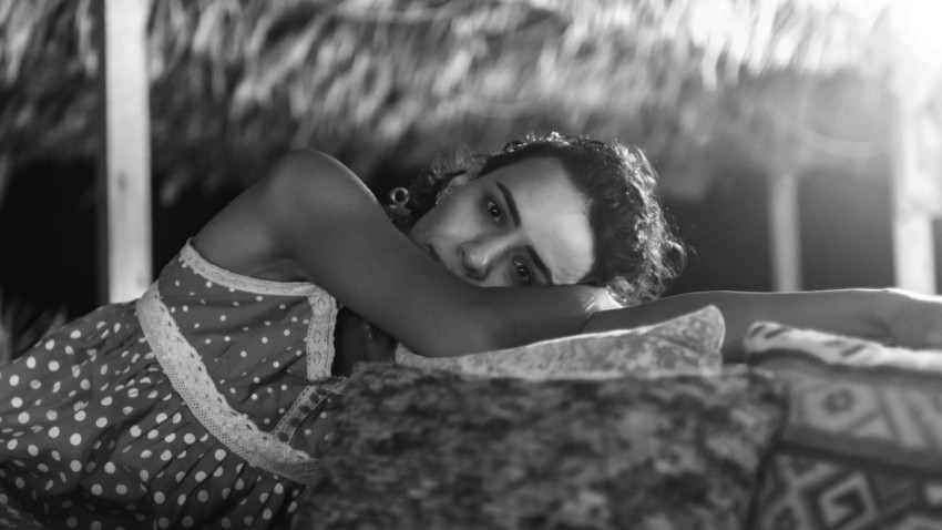 a black and white photo of a woman laying on a bed