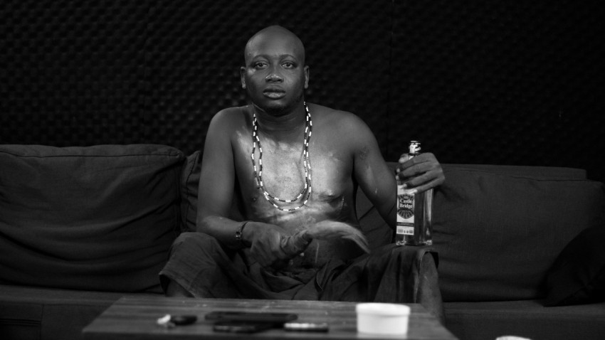 a man sitting on a couch holding a bottle of beer