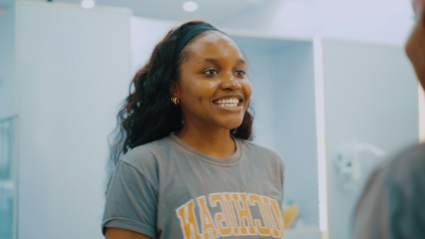 a woman in a gray shirt is smiling