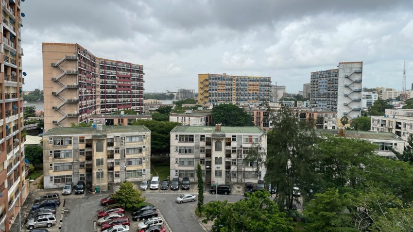 cars parked on parking lot near high rise buildings during daytime