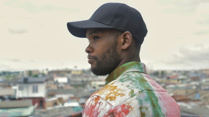 man in green and white floral shirt wearing black cap