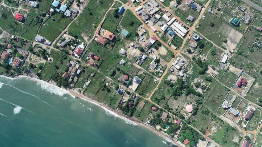 aerial view of houses near body of water during daytime