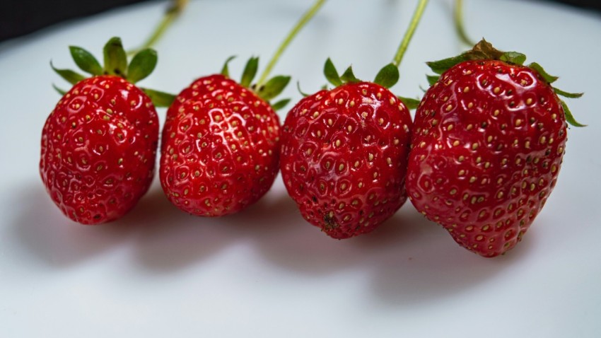 a group of three strawberries sitting on top of a table