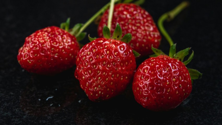 a group of three strawberries sitting on top of a table