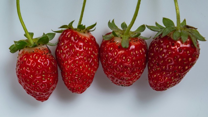 a group of three strawberries sitting on top of each other